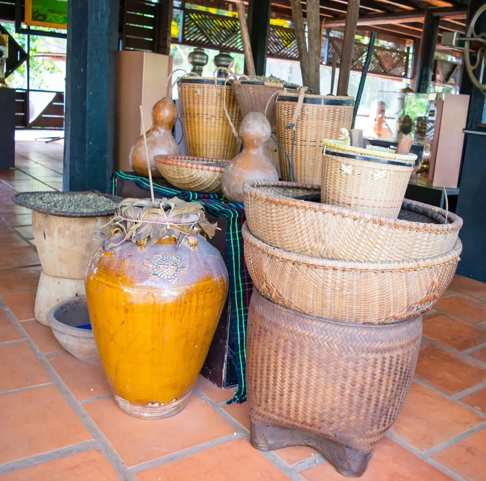Stacked hand-woven baskets beside a large yellow glazed jar